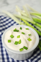 Fresh sour cream with onion on fabric, closeup