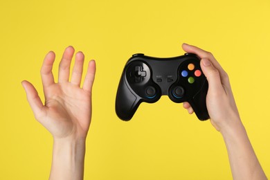 Photo of Woman with game controller on yellow background, closeup