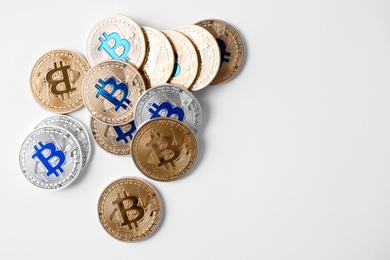 Golden and silver bitcoins on white background, top view