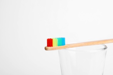 Photo of Glass with bamboo toothbrush on white background