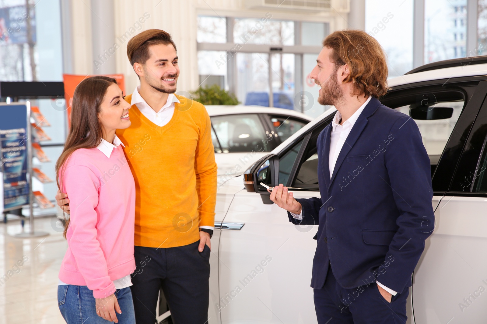 Photo of Car salesman working with couple in dealership