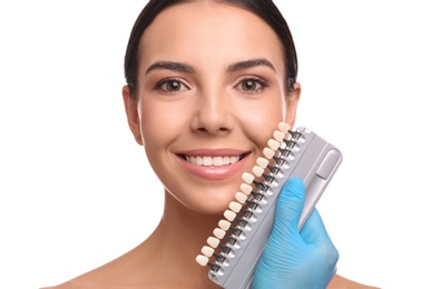 Photo of Doctor checking young woman's teeth color on white background. Cosmetic dentistry