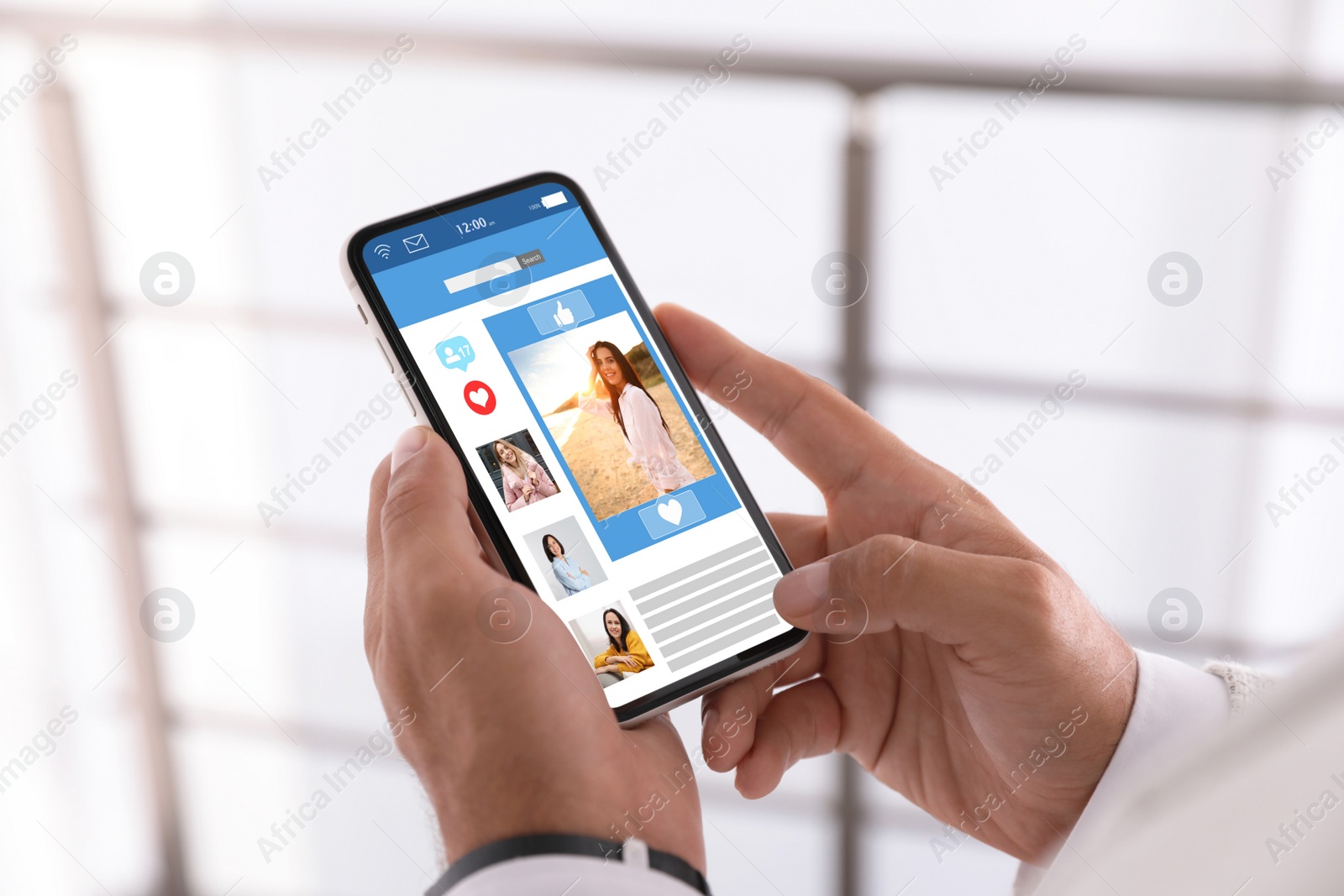 Image of Young man visiting online dating site via smartphone indoors, closeup