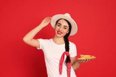 Beautiful young woman with French fries on red background