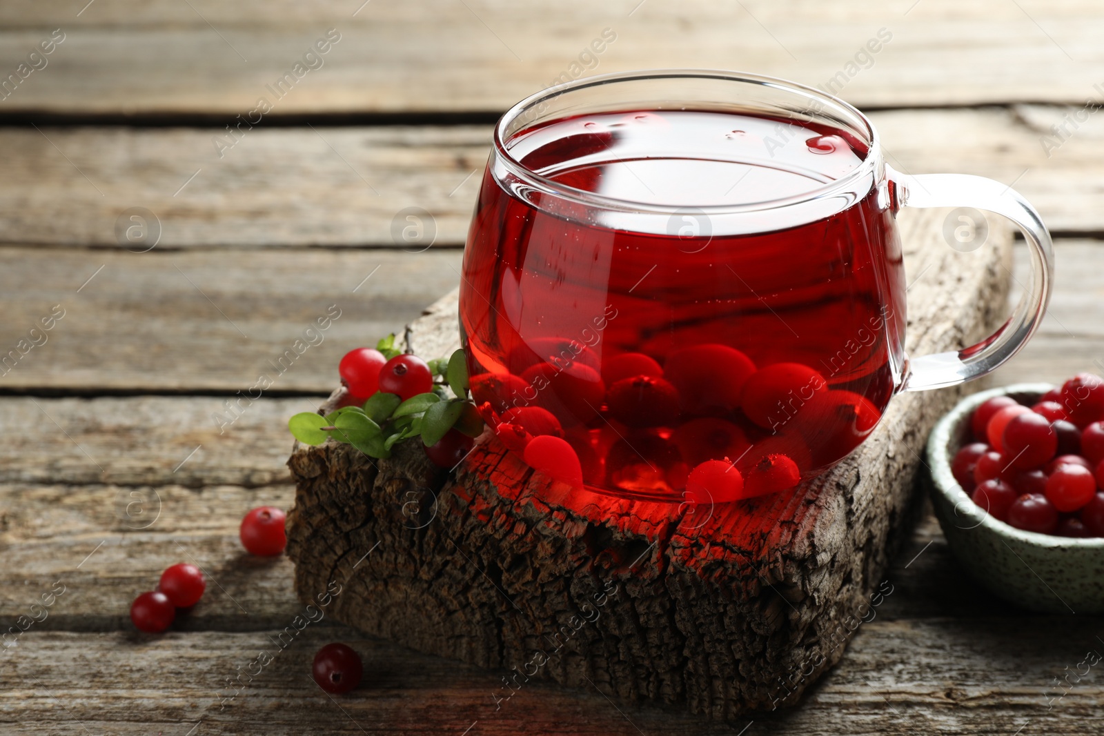 Photo of Delicious cranberry tea and berries on wooden table