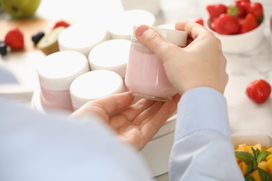 Woman making tasty yogurt at white marble table, closeup