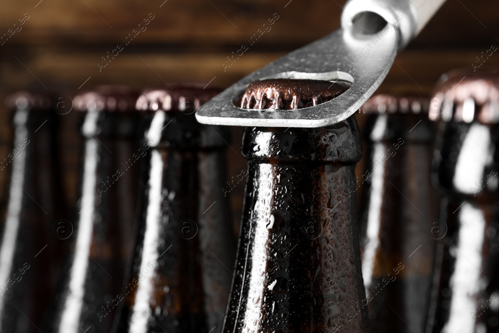 Photo of Opening bottle of beer on wooden background, closeup. Space for text