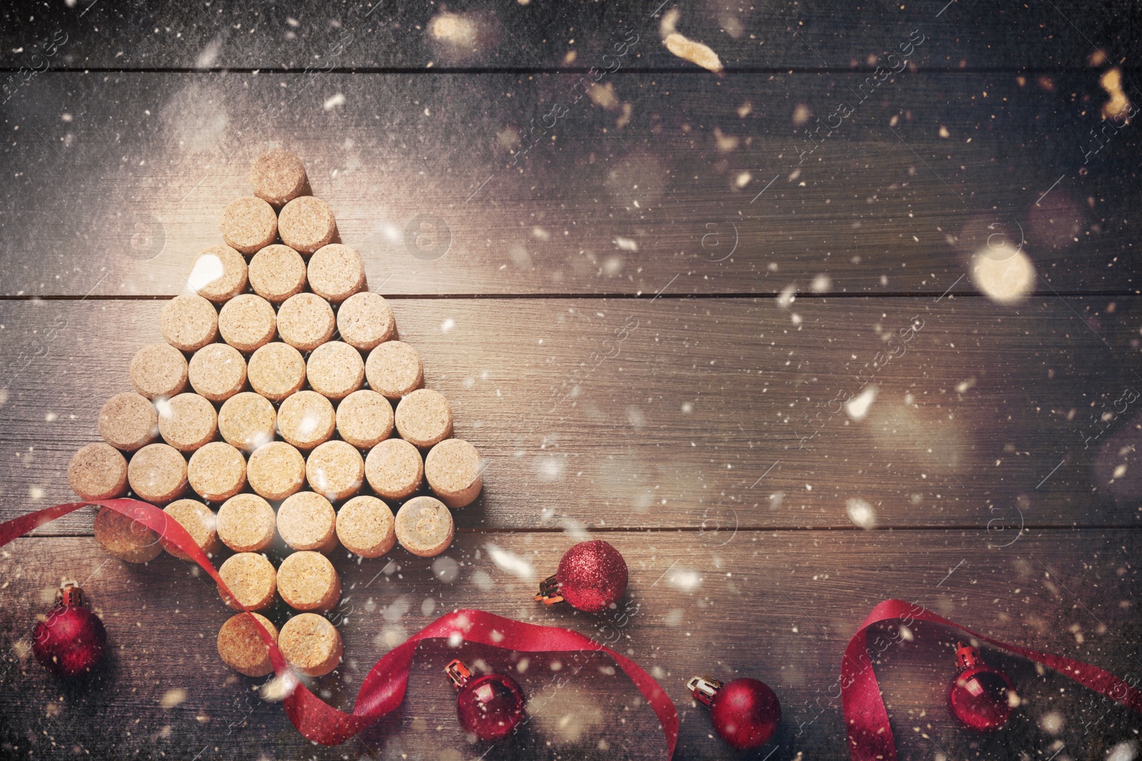 Image of Christmas tree made of wine corks, red ribbon and baubles on wooden table, flat lay. Space for text