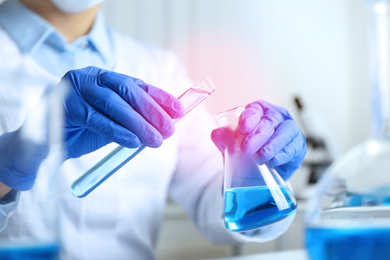 Image of Scientist pouring liquid into flask, closeup. Laboratory analysis