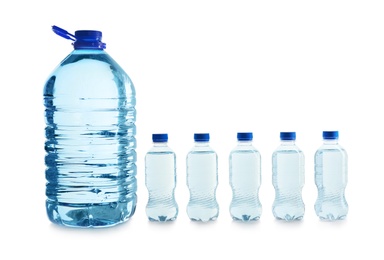 Photo of Large and small bottles of water on white background