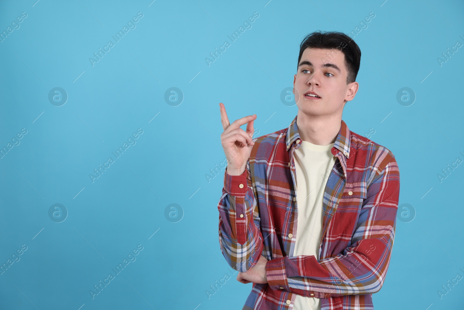 Photo of Eureka! Portrait of thoughtful young man on light blue background, space for text