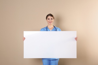 Photo of Medical student with blank poster on color background. Space for text