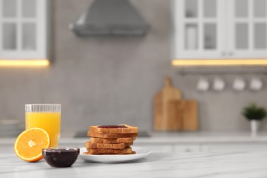 Breakfast served in kitchen. Crunchy toasts, jam and orange fresh on white table. Space for text