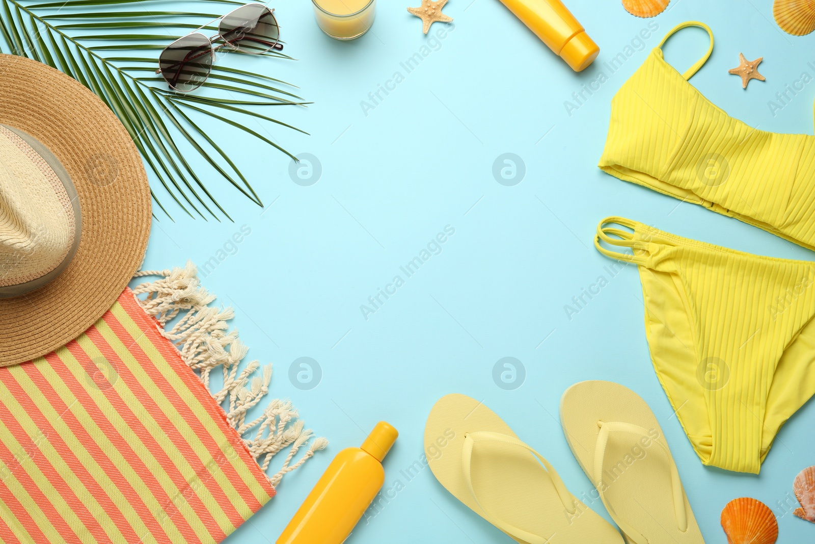 Photo of Frame made with different beach objects on light blue background, flat lay. Space for text