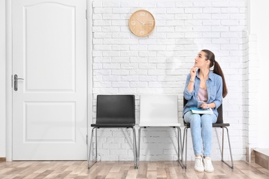 Young woman waiting for job interview, indoors