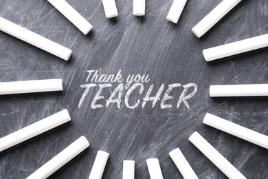 Image of Phrase Thank You Teacher written on blackboard and pieces of chalk, flat lay