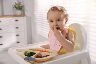 Cute little baby wearing bib while eating at home