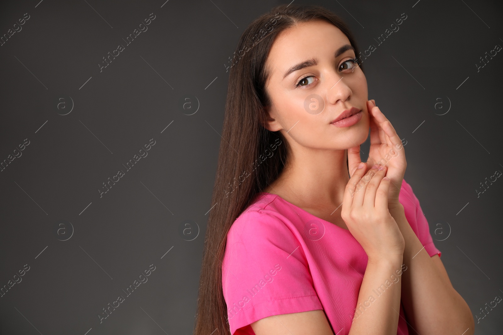 Photo of Portrait of beautiful young woman on dark grey background. Space for text