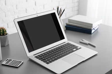 Modern laptop with blank screen on table. Space for design