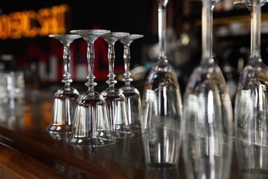 Photo of Different empty clean glasses on counter in bar