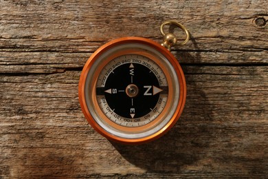 Photo of One compass on wooden table, top view