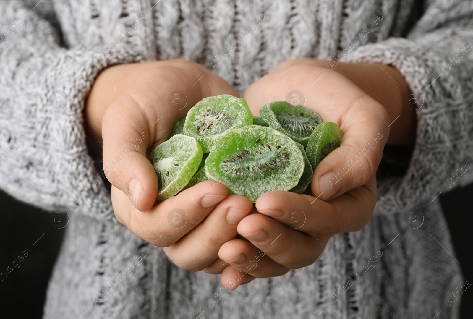 Photo of Woman holding handful of tasty kiwi, closeup. Dried fruit as healthy food