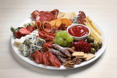 Photo of Plate of different appetizers with dip sauce on white wooden table, closeup