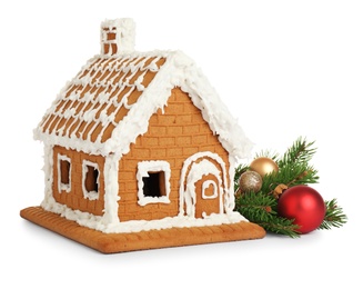 Photo of Beautiful gingerbread house decorated with icing and fir branch on white background