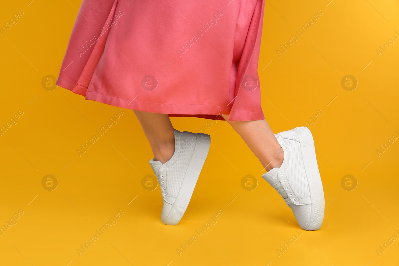 Photo of Woman wearing stylish shoes on yellow background, closeup