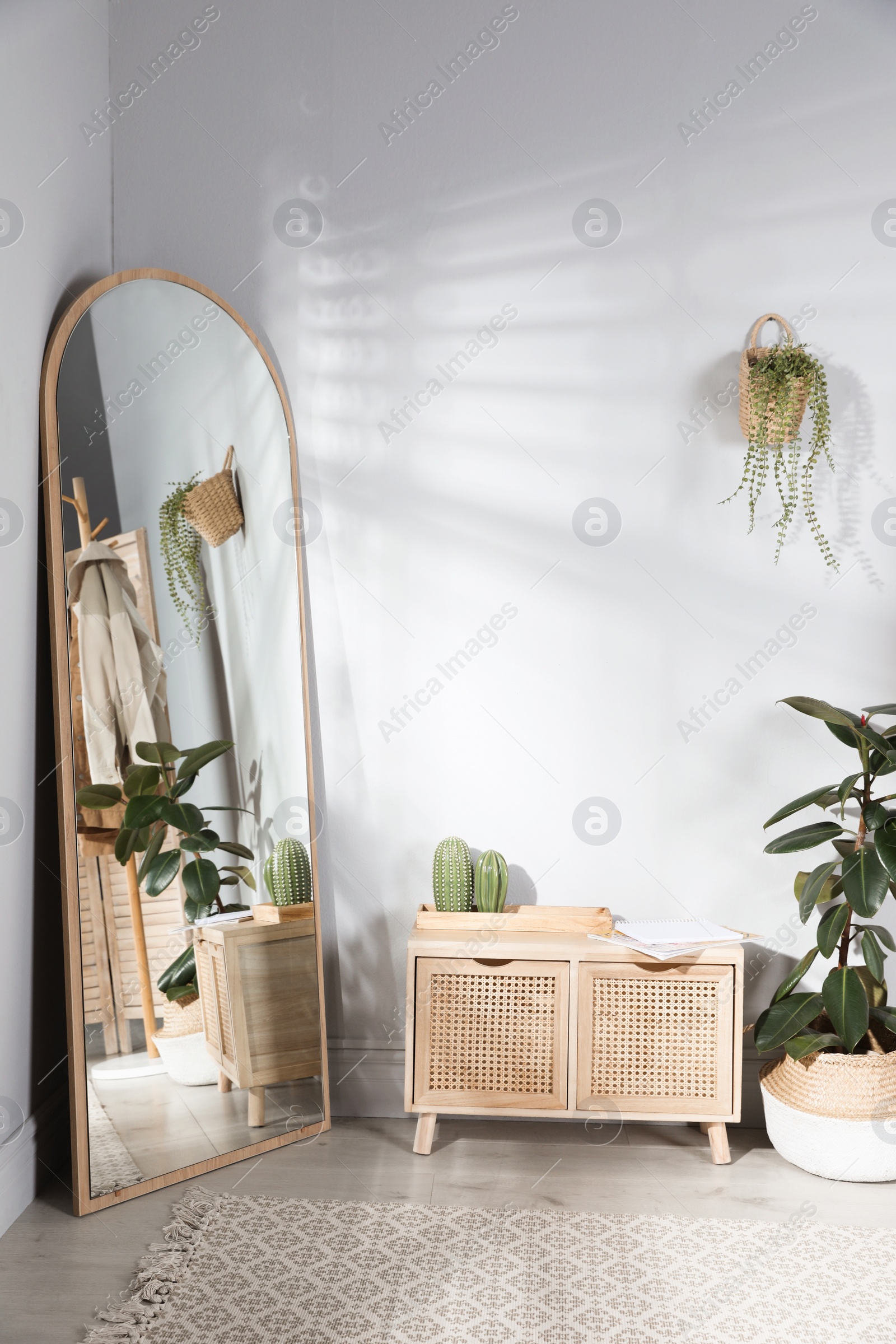 Photo of Stylish hallway room interior with wooden commode and large mirror