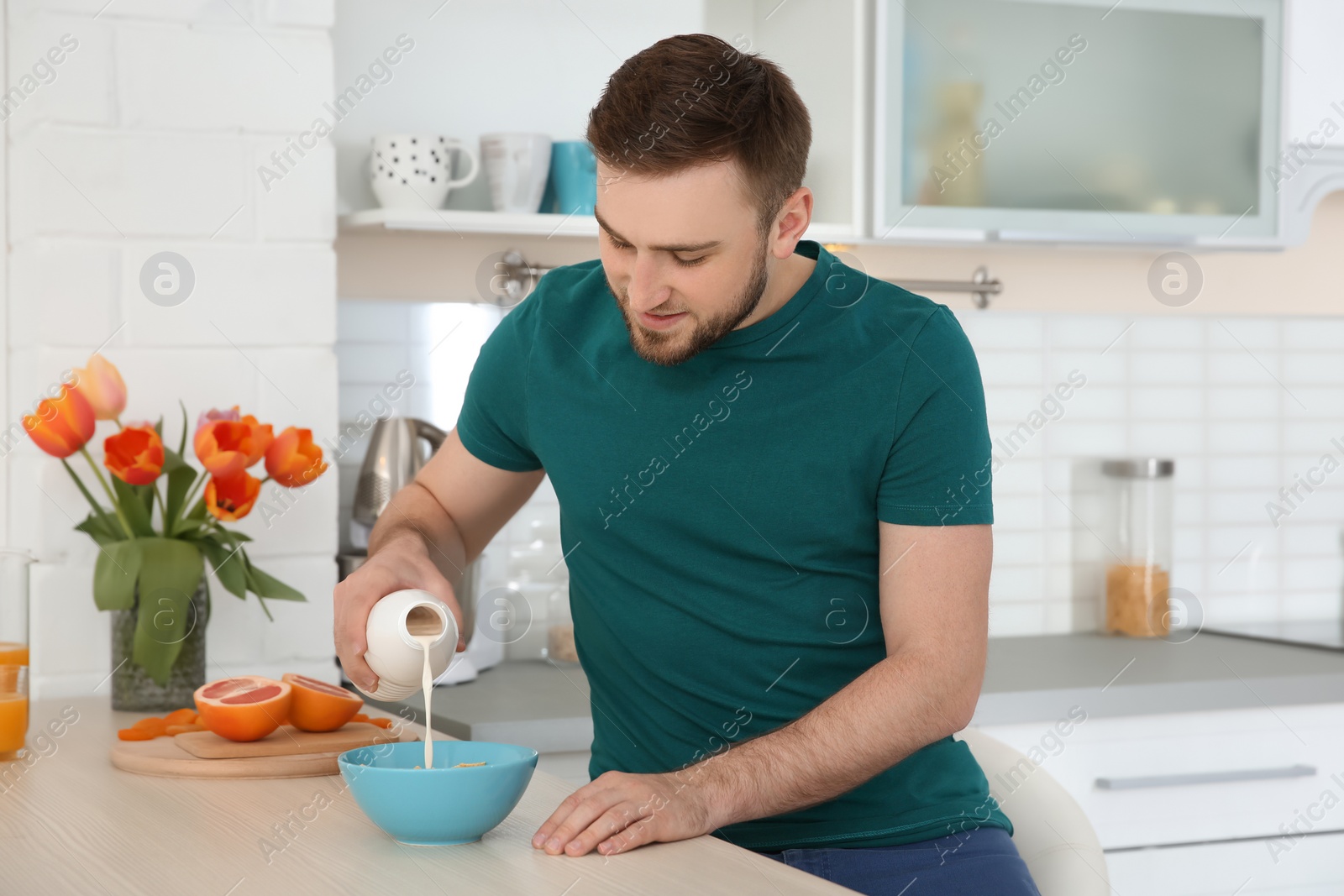 Photo of Young man having breakfast with tasty milk at home