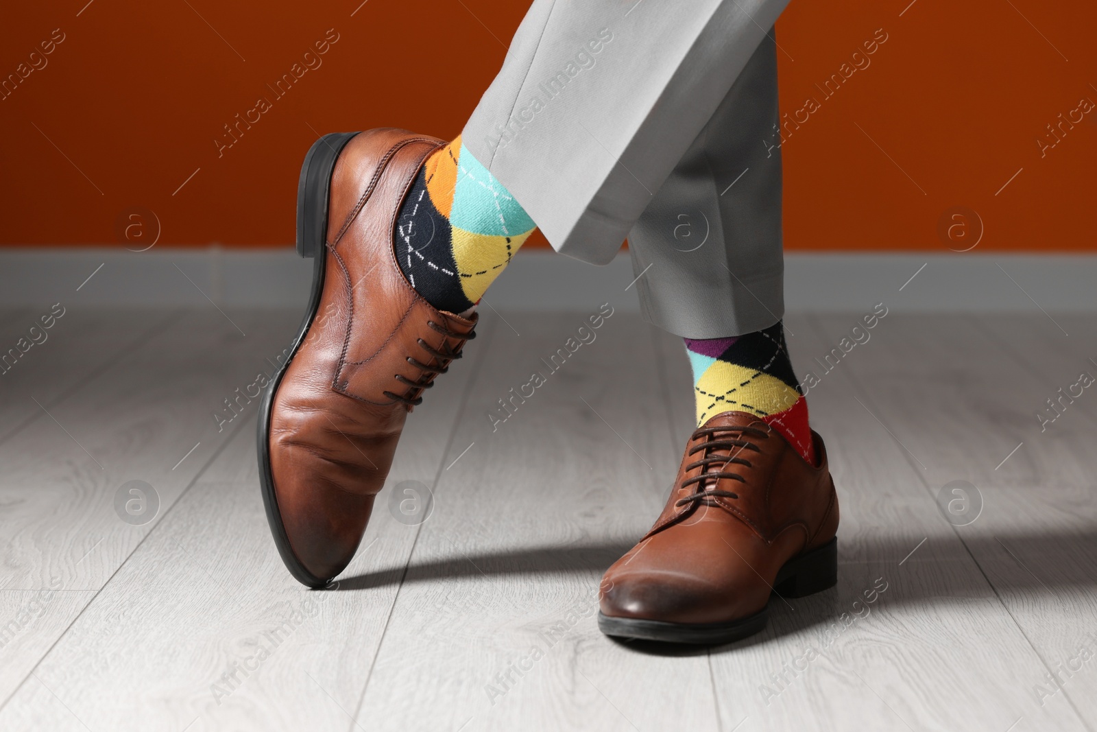 Photo of Man wearing stylish shoes and colorful socks indoors, closeup