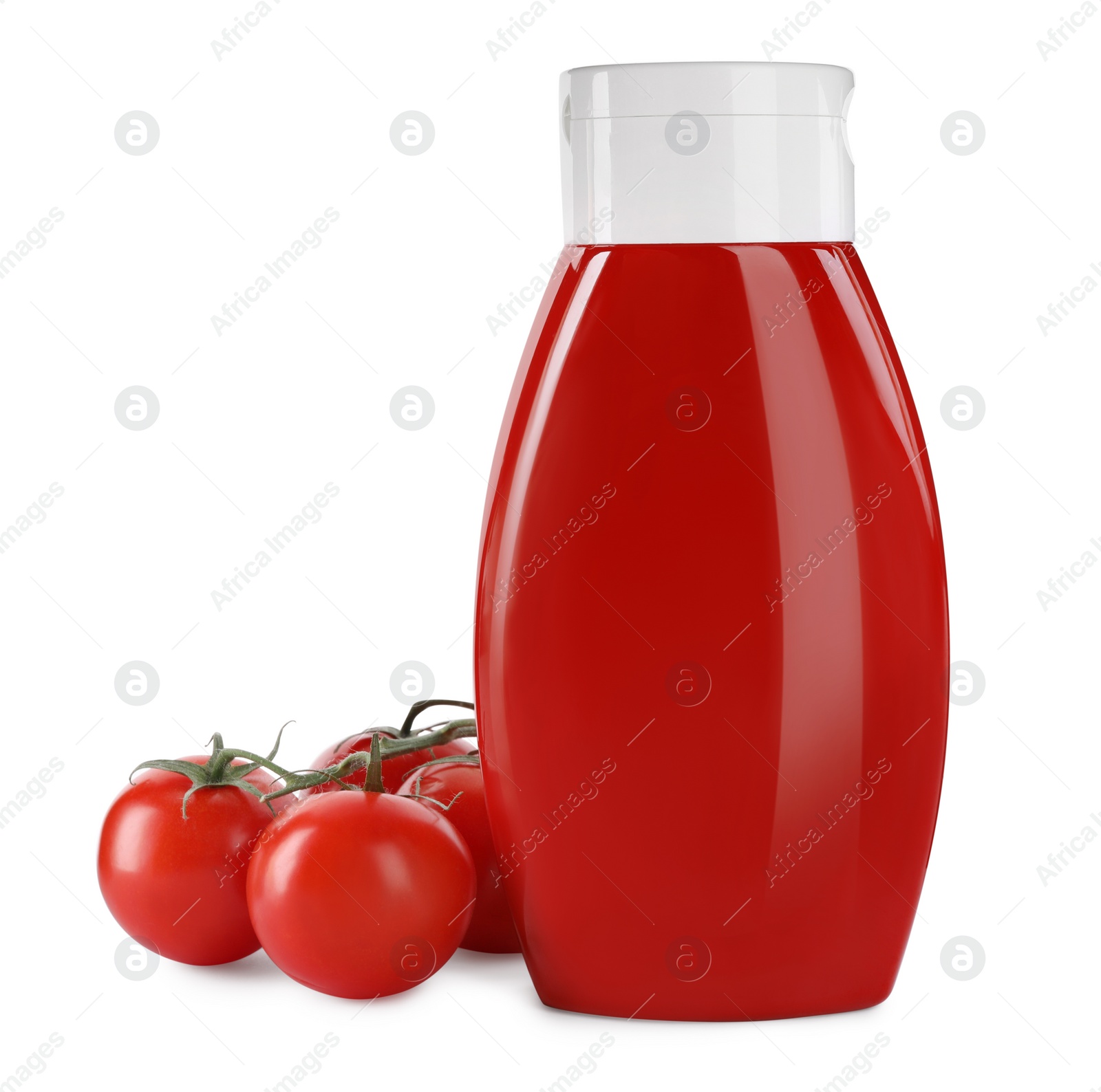 Photo of Bottle of tasty ketchup and fresh tomatoes isolated on white