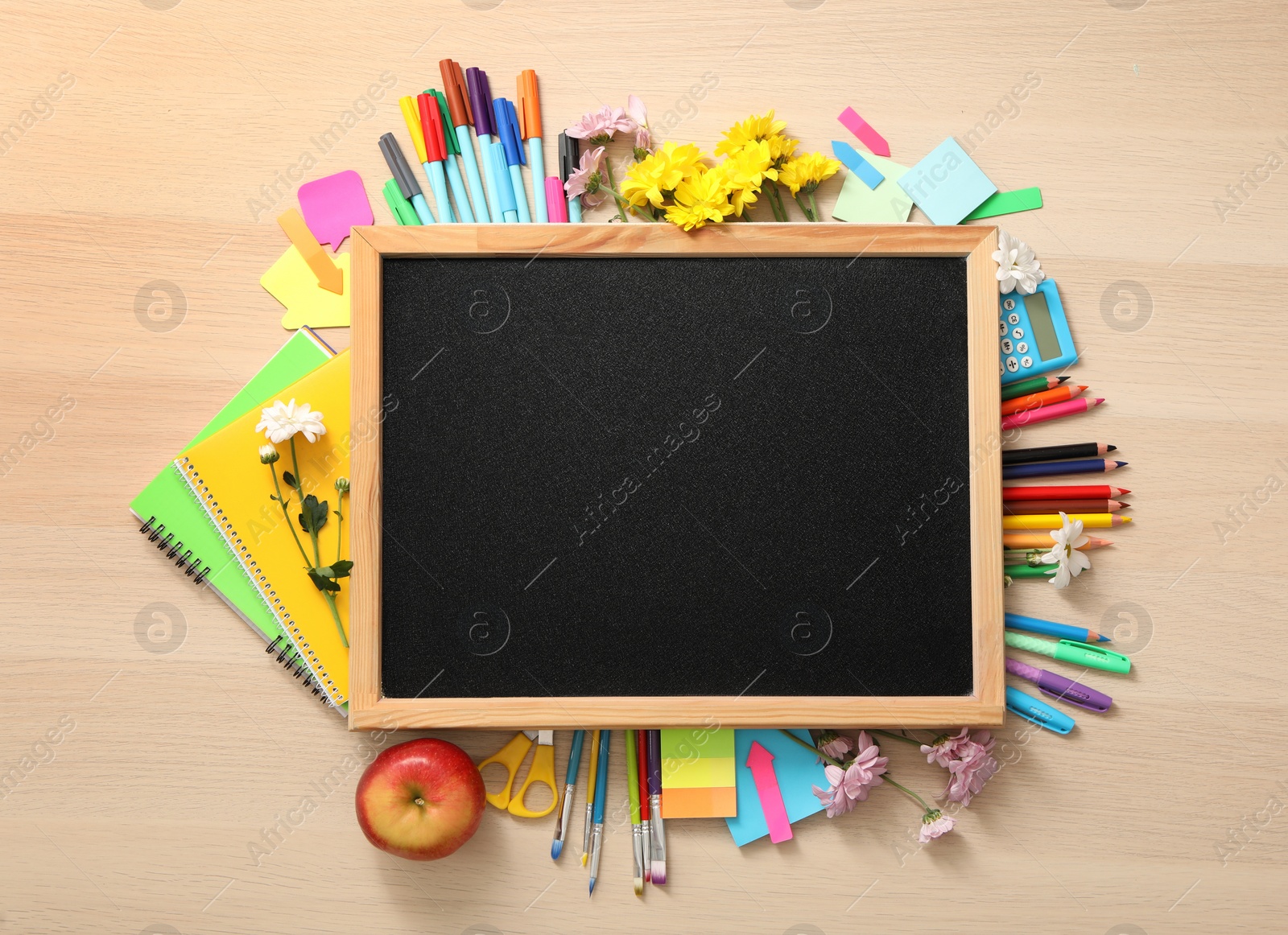 Photo of Blackboard, stationery, apple and flowers on wooden table, flat lay with space for text. Teacher's Day