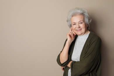 Portrait of mature woman on color background. Space for text