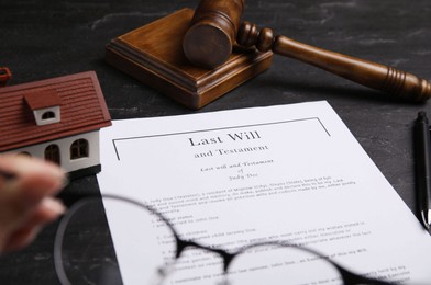 Photo of Last will and testament near house model, gavel on black table