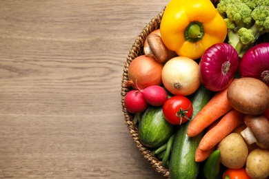 Photo of Different fresh vegetables on wooden table, top view. Space for text