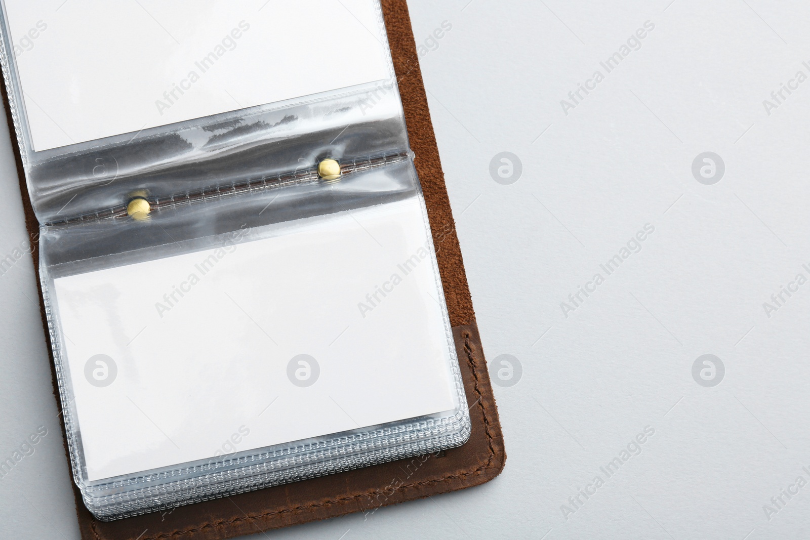 Photo of Leather business card holder with blank cards on light grey background, top view. Space for text