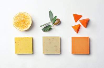 Flat lay composition with handmade soap bars and ingredients on white background