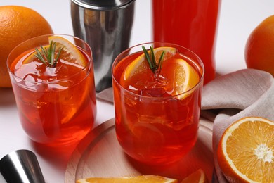 Aperol spritz cocktail, rosemary and orange slices on white wooden table