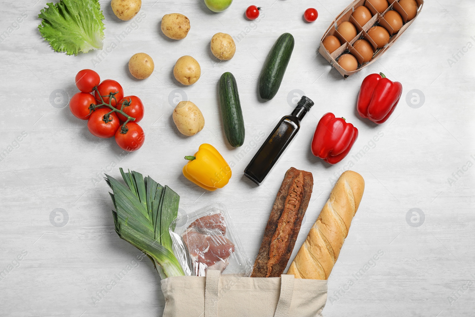 Photo of Fresh vegetables and other products on light grey background, flat lay