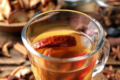 Photo of Delicious compote with dried apple slices in glass cup, closeup