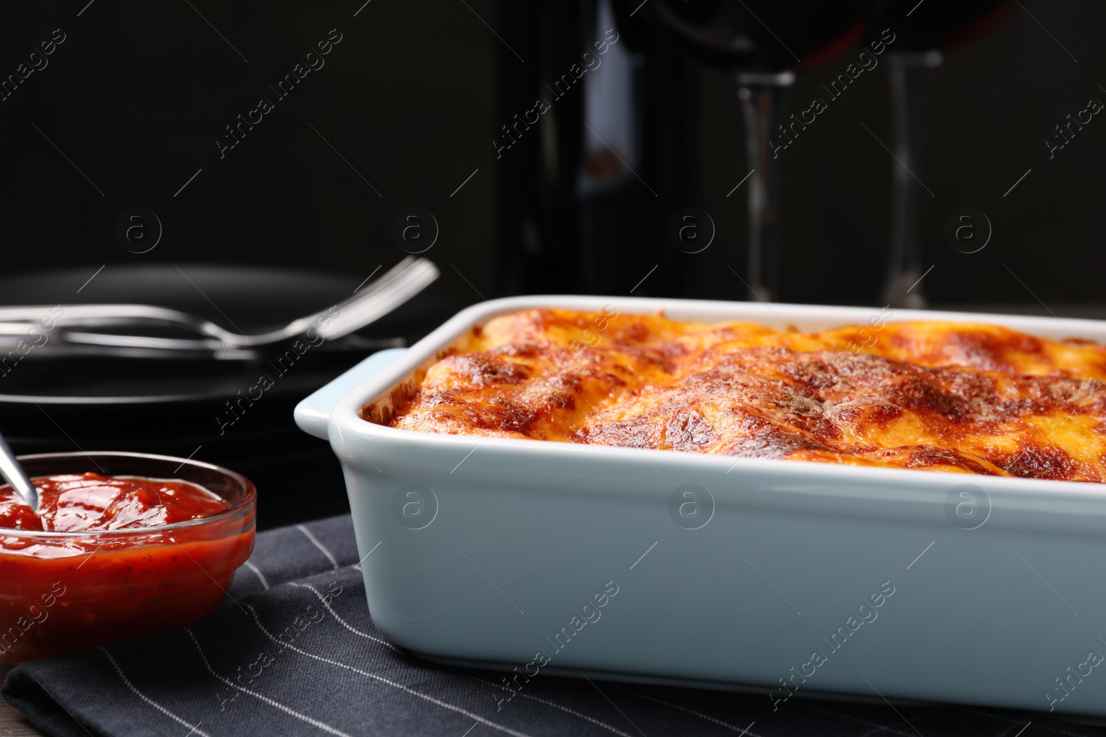 Photo of Tasty cooked lasagna in baking dish on table, closeup