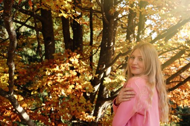 Portrait of beautiful young woman in autumn forest. Space for text