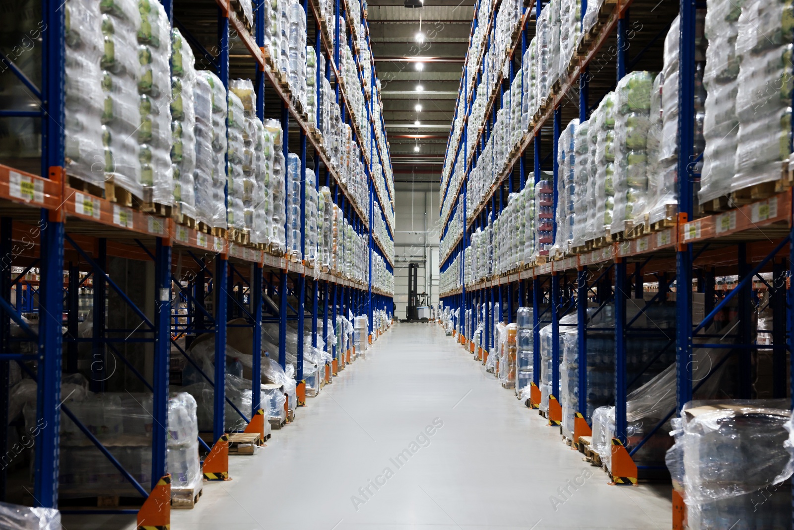 Photo of Warehouse interior with metal racks full of merchandise. Wholesale business