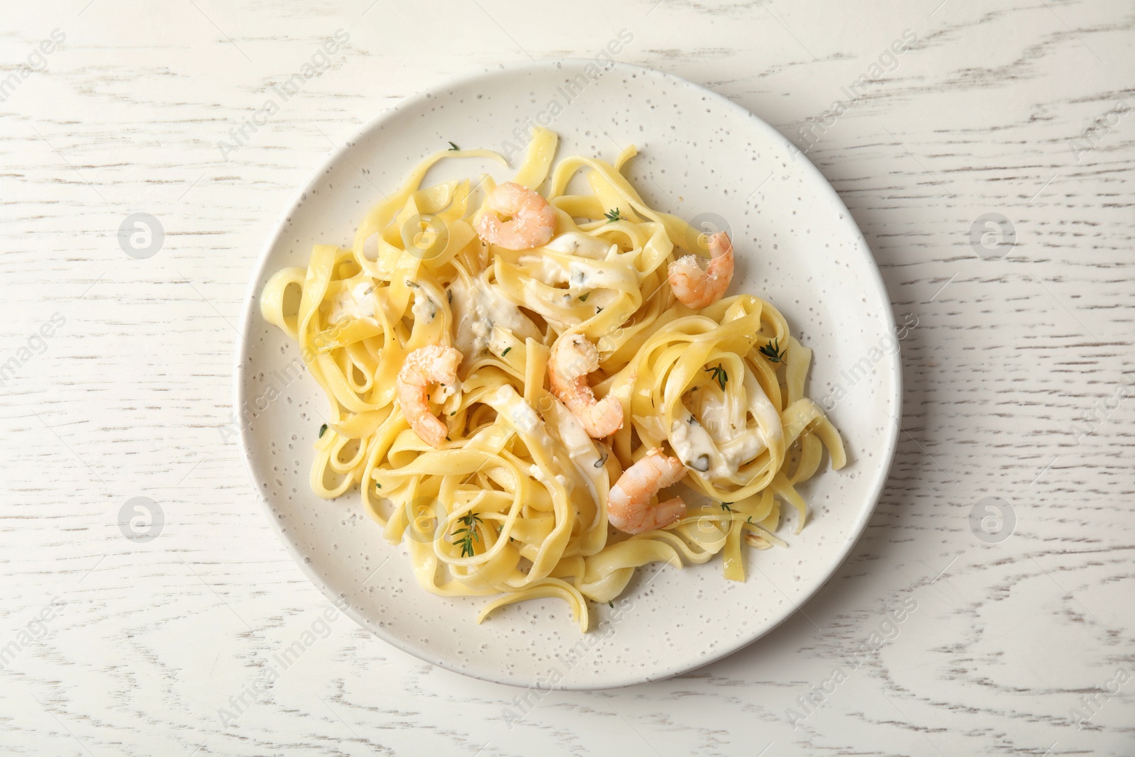 Photo of Delicious pasta with shrimps on white wooden table, top view