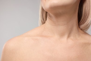 Woman with healthy skin on grey background, closeup