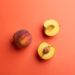 Flat lay composition with fresh peaches on coral background