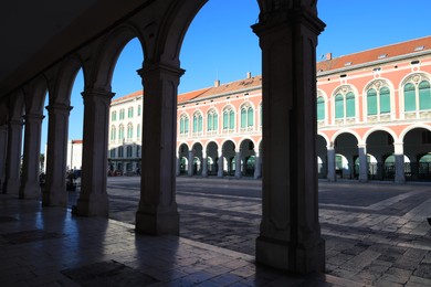 Photo of Beautiful view of old building with columns and square on sunny day