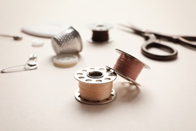 Metal spools with threads on table. Tailoring equipment